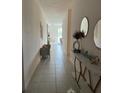 Inviting hallway with stylish console table, round mirrors and a gray sitting chair at 522 Feltrim Manor Rd, Haines City, FL 33844