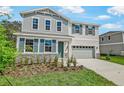 Lovely two-story home features light blue siding, shuttered windows, stone accents, and a large driveway at 565 Summit River Dr, Apopka, FL 32712