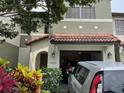 Charming two-story townhome with a red tile roof and an attached one-car garage at 5930 Tivoli Gardens Blvd, Orlando, FL 32829