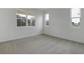 Bright bedroom featuring neutral carpet, three windows, and fresh paint at 630 Summit River Dr, Apopka, FL 32712