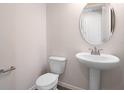 Neat powder room featuring a pedestal sink, oval mirror and a modern toilet at 640 Summit River Dr, Apopka, FL 32712