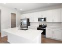 Modern white kitchen with stainless steel appliances, a central island, and a walk-in pantry at 640 Summit River Dr, Apopka, FL 32712