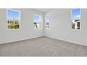 Bright, carpeted bedroom with ample natural light from multiple windows offers a calm and inviting space at 665 Summit River Dr, Apopka, FL 32712
