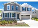 Charming two-story home features a two-car garage, stone accents, neutral colors, and a well-maintained front yard at 665 Summit River Dr, Apopka, FL 32712