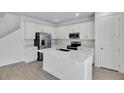 Modern kitchen with white cabinets, stainless steel appliances, a large island, and wood-look flooring at 665 Summit River Dr, Apopka, FL 32712