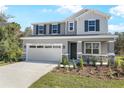 Charming two-story home featuring a gray exterior, two-car garage, and well-manicured landscaping at 675 Summit River Dr, Apopka, FL 32712