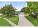 A well-kept home with a beautiful lawn and a long driveway leading to the attached garage at 736 Forest Glen Ct, Maitland, FL 32751