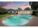 Backyard with a large in-ground pool surrounded by a concrete deck, a screened-in lanai, and lush green grass at 736 Forest Glen Ct, Maitland, FL 32751