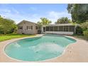 A backyard featuring a large in-ground pool with a screened-in lanai and green lawn at 736 Forest Glen Ct, Maitland, FL 32751