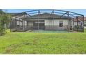 The backyard of the home features a screened-in pool and a well manicured lawn at 163 Kenny Blvd, Haines City, FL 33844