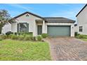 Charming single-Gathering home with a neat lawn, brick driveway and attached two-car garage at 163 Kenny Blvd, Haines City, FL 33844