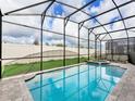 Sparkling pool and jacuzzi with a screened enclosure, and a backyard that offers relaxation and recreation at 1810 Caribbean View Ter, Kissimmee, FL 34747
