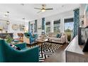 Open-concept living room with stylish furniture, large windows, and a view into the dining area at 1856 Castleton Dr, St Cloud, FL 34771