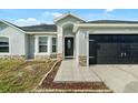 Inviting front entrance with tiled walkway, decorative stone accents, and black front door at 1913 Manatee Ct, Kissimmee, FL 34759