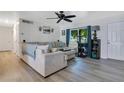 Bright living room boasts a neutral color palette, ceiling fan, and an oversized window for great natural light at 2 S Lavon Ave, Kissimmee, FL 34741
