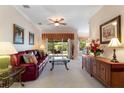 Cozy living room featuring plush carpeting, a ceiling fan, a comfortable red couch, and sliding doors to the patio at 214 Verona Dr, Kissimmee, FL 34759