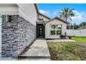 Home featuring a clean front entrance and modern stone accents at 2561 Montego Bay Blvd, Kissimmee, FL 34746
