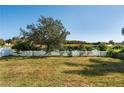 Expansive backyard with a white picket fence and views of the lake, great for outdoor enjoyment at 2703 Eagle Canyon S Dr, Kissimmee, FL 34746