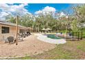 Beautiful backyard with in-ground pool, patio, lounge chairs, and mature trees at 4410 Mildred Bass Rd, St Cloud, FL 34772