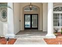 Elegant entryway with double doors, column supports, herringbone brick flooring, and pendant lighting at 5254 Mill Stream Dr, St Cloud, FL 34771