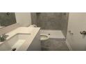 Bathroom features a tiled shower, a toilet, and a vanity with a sink at 553 Se Turtle, Haines City, FL 33844