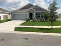 Well-maintained single-Gathering home with green lawn, tidy landscaping, and attached garage in a suburban setting at 553 Sea Turtle Ln, Haines City, FL 33844