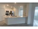 Modern kitchen features white cabinetry, stainless steel appliances, and a large island with a countertop at 553 Se Turtle, Haines City, FL 33844