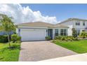 Beautiful home featuring a brick driveway, lush lawn, and manicured landscaping at 5648 Cedar Chase Dr, St Cloud, FL 34771