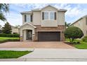 Charming two-story home featuring a brick-paved driveway, stone accents, and a welcoming front entrance at 7541 Marker Ave, Kissimmee, FL 34747