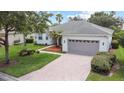 Beautiful single-story home with brick driveway, manicured lawn, and attached two-car garage at 759 Largo Pass, Poinciana, FL 34759