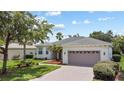 Inviting single-story home with a brick driveway, lush landscaping, and an attached two-car garage at 759 Largo Pass, Poinciana, FL 34759