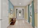 Inviting foyer with neutral tile floors, a striking accent wall, and bright, natural light at 7613 Brookhurst Ln, Kissimmee, FL 34747