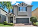 Charming two-story home features a brick driveway, well-manicured lawn, and a neutral-colored exterior at 7613 Brookhurst Ln, Kissimmee, FL 34747