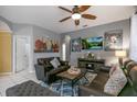 Comfortable living room featuring tile flooring, ceiling fan, large window and leather furniture at 7751 Tosteth St, Kissimmee, FL 34747