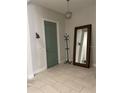 Inviting entryway with stylish light fixture, large mirror, coat rack and tiled floors at 8919 Lakeshore Pointe Dr, Winter Garden, FL 34787
