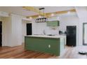 Modern kitchen featuring a central island, stainless steel appliances, and stylish light fixture at 9345 Atlanta Dr, St Cloud, FL 34773