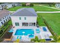 Backyard features a pool, spa, outdoor kitchen, seating area, ping pong table, and putting green at 1005 Coyote Creek Way, Reunion, FL 34747