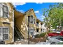 View of the condo building's entrance with stairs leading to upper-level units and manicured landscaping at 1025 S Hiawassee Rd # 2225, Orlando, FL 32835
