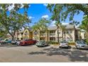 Exterior view of the condo building showcasing its architectural style, landscaping, and parking area at 1025 S Hiawassee Rd # 2225, Orlando, FL 32835