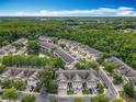 Aerial view of the townhome community featuring a small lake and a wooded perimeter at 10746 Regent Square Dr # 1502, Orlando, FL 32825