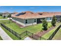 Fenced backyard featuring green lawn and solar panels on the roof at 1101 Downswing Pl, Davenport, FL 33896