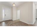 Bright foyer with wood-look tile flooring and a view of the front door at 1101 Downswing Pl, Davenport, FL 33896