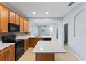 Bright kitchen featuring stainless steel appliances, wood cabinetry, and a center island with quartz counters at 13636 Beauregard Pl, Orlando, FL 32837