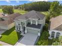 Aerial view of a two-story home with a manicured lawn in a suburban neighborhood at 14412 Saint Georges Hill Dr, Orlando, FL 32828
