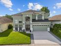 Two-story home boasting a manicured lawn, lush landscaping, and a two-car garage at 14412 Saint Georges Hill Dr, Orlando, FL 32828