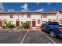 Townhouse featuring a stucco facade, red trim, and reserved parking spaces at 1614 Shady Ridge Ct # 252, Orlando, FL 32807
