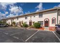 Townhouse featuring a stucco facade, red trim, and reserved parking spaces at 1614 Shady Ridge Ct # 252, Orlando, FL 32807