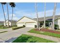 Delightful one-story villa with a verdant lawn and swaying palm trees presenting a serene, Floridian style at 168 Club Villas Ln, Kissimmee, FL 34744