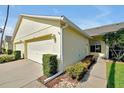 Charming one-story home with attached garage showcasing a well-maintained yard with decorative landscaping at 168 Club Villas Ln, Kissimmee, FL 34744