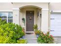 Inviting front porch featuring a brown front door, potted plants, and tasteful decorations at 176 Sofia Ln, Lake Alfred, FL 33850